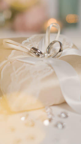 Vertical-Video-Close-Up-Of-Wedding-Rings-For-Bride-And-Groom-On-Small-Decorated-Cushion-3